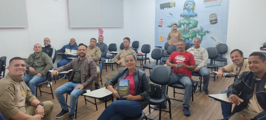 guardas portuários estão sentados em cadeiras de sala de aula. eles sorriem para a foto. #paratodosverem 
