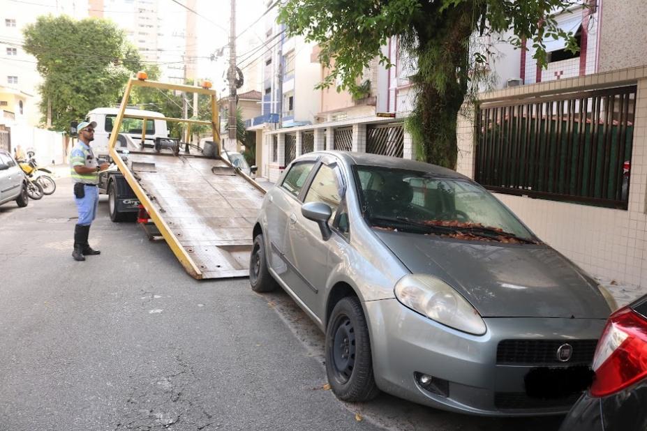 carro parado em rua está sendo guinchado. Há um agente da CET na rua. #paratodosverem 