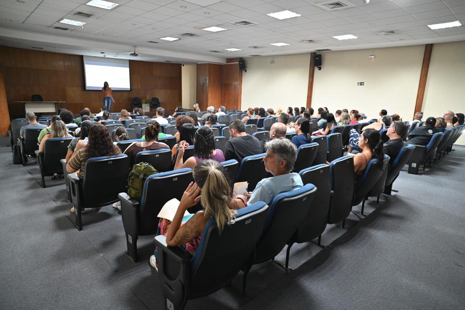 profissionais assistem palestra em auditório. #paratodosverem