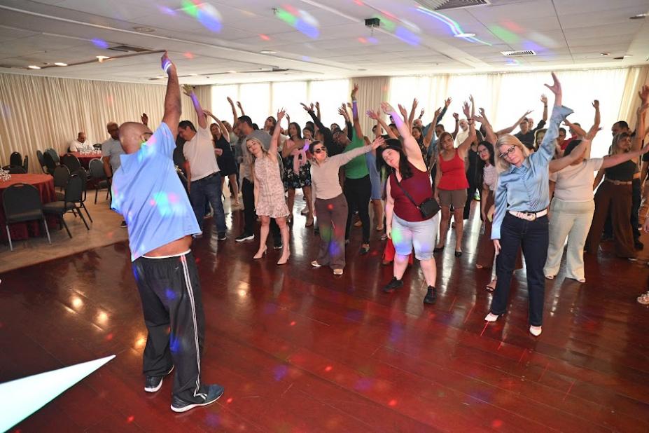 pessoas em pé fazendo movimento de dança. #paratodosverem 