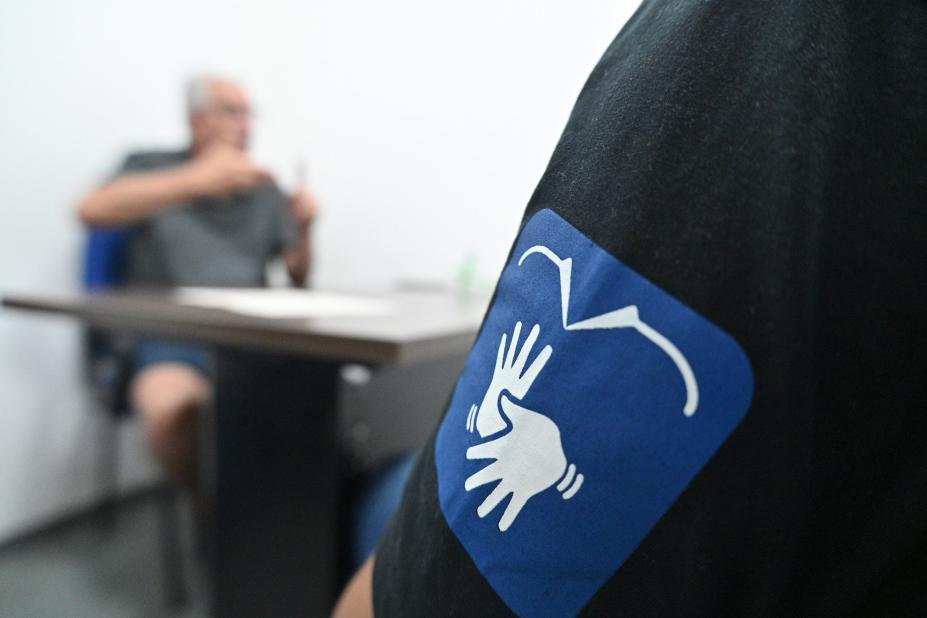 logo da central de libras em primeiro plano, com homem ao fundo. #paratodosverem