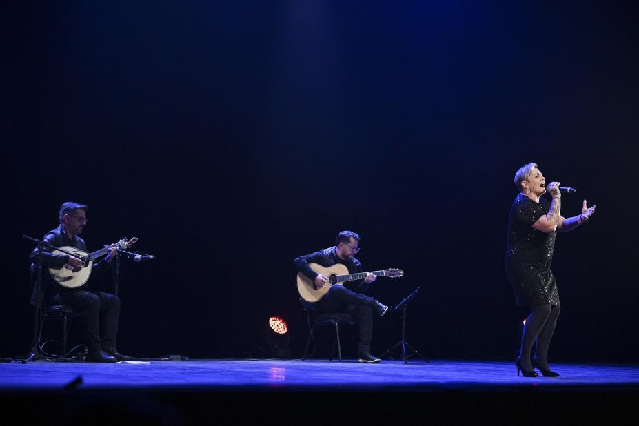 cantora e dois músicos em palco. #paratodosverem