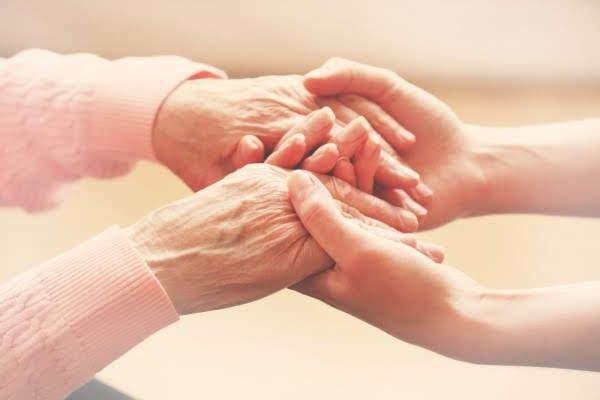 mãos de pessoa mais jovens seguram maãos de pessoa idosa. #paratodosverem 