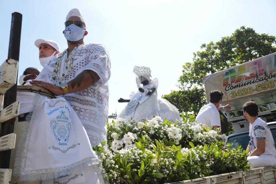 imagem de iemanja cercada de flores e pessoas em cima do carro #paratodosverem