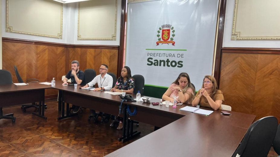 cinco pessoas sentadas em sala na prefeitura olhando para frente #paratodosverem