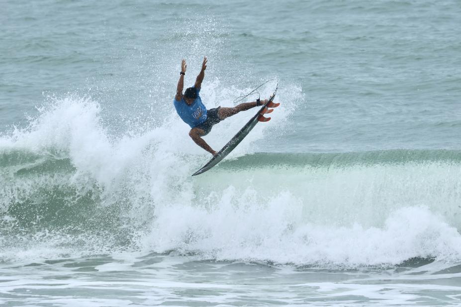 surfista faz manobra pulando em onda #paratodosverem