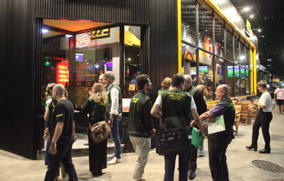 fiscais uniformizados do procon em frente a um bar. #paratodosverem