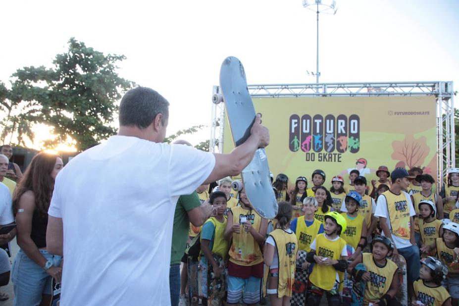 alunos posam para foto diante de painel onde se lê Futuro do Skate. #paratodosverem