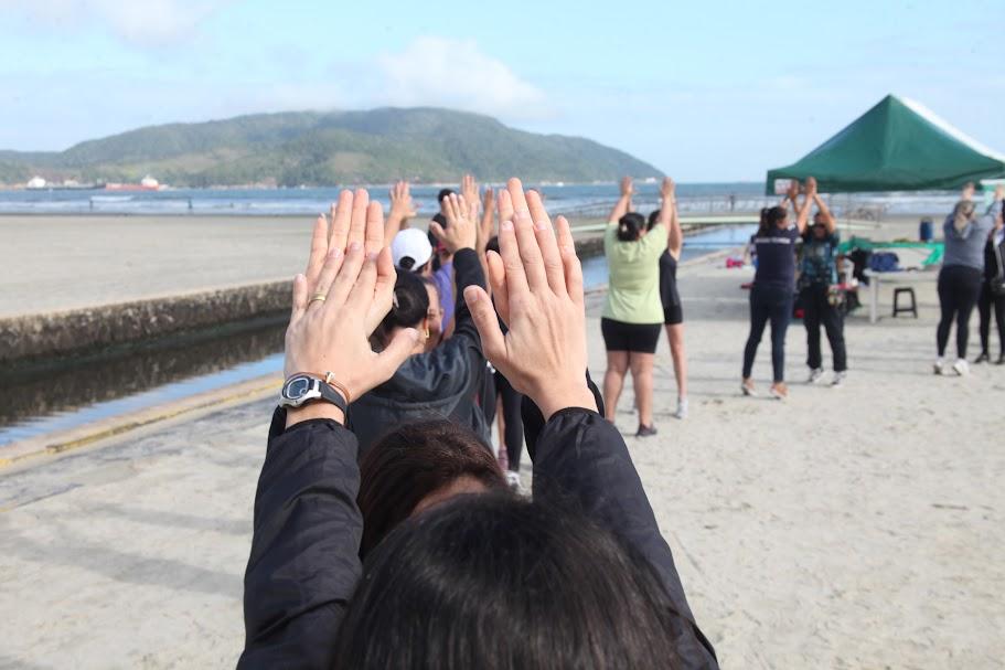 pessoas se exercitando com as mãos ao alto #paratodosverem