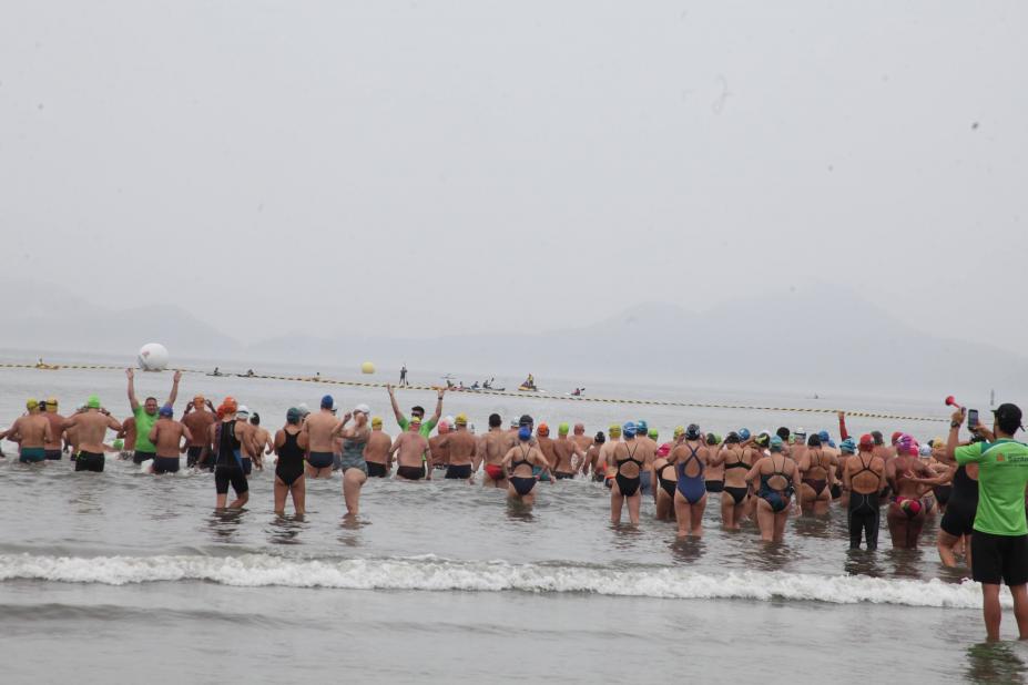 nadadores estão na beira do mar para iniciar prova. #paratodosverem 