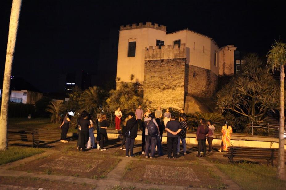 grupo de estudantes em torno de monumento. #paratodosverem 