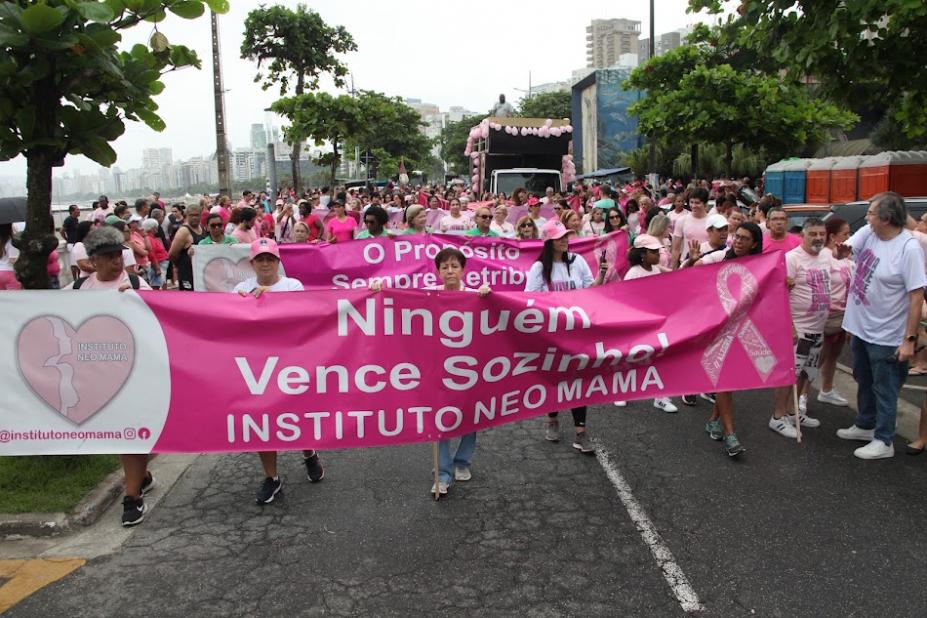 caminhada com faixas e pessoas vestidas de cor-de-rosa. #paratodosverem 