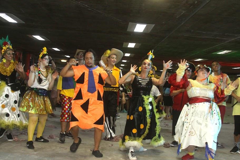 pessoas fantasiadas para o carnaval dançam animadas #paratodosverem 