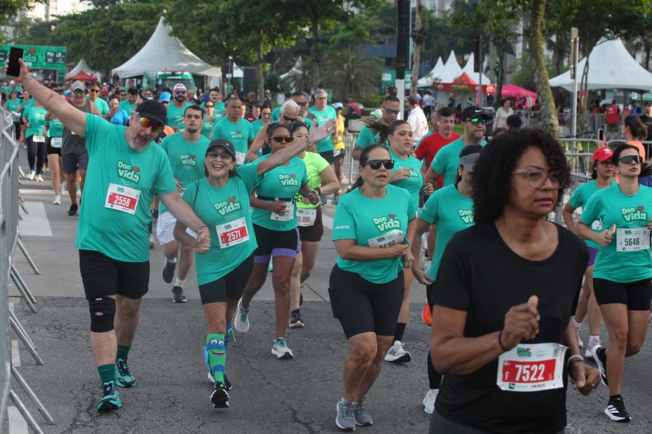 pessoas uniformizadas correndo na orla. #paratodosverem
