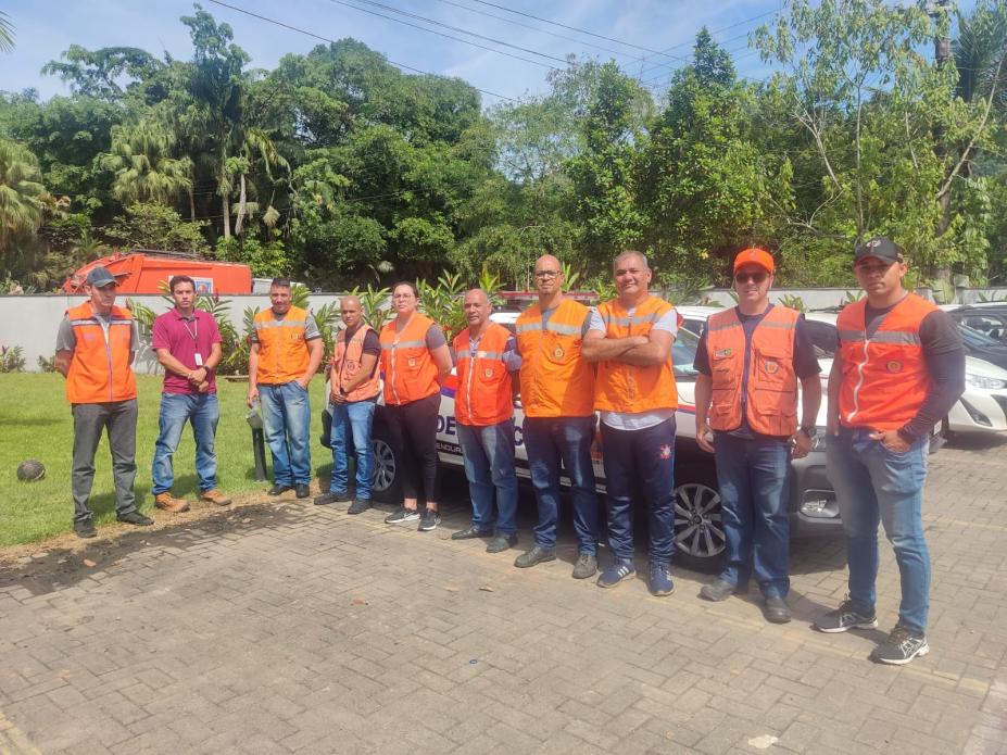 integrantes da defesa civil usando coletes posam para foto. #paratodosverem