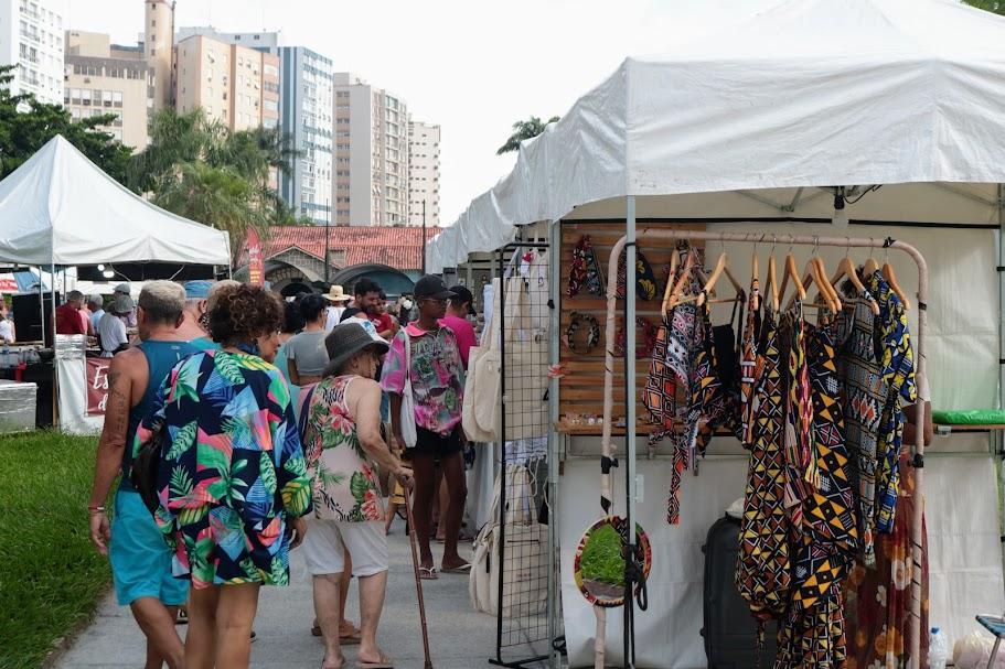 pessoas olhando artigos na feira #paratodosverem