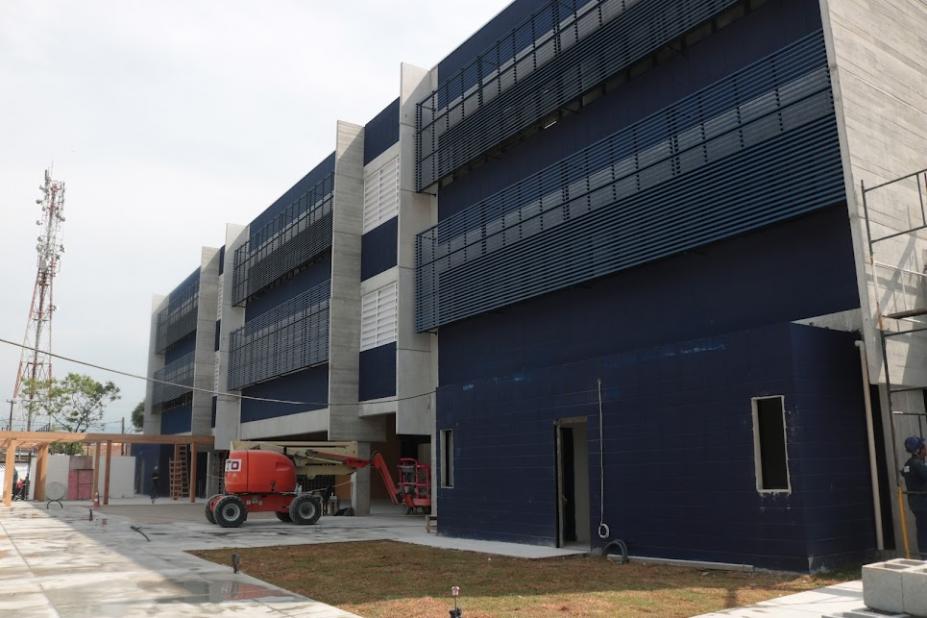 fachada de escola com trator na porta. Sua estrutura é azul marinho e branca. #paratodosverem