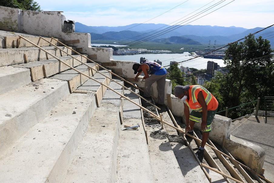 homens finalizam construção de escadaria no alto de um morro. #paratodosverem