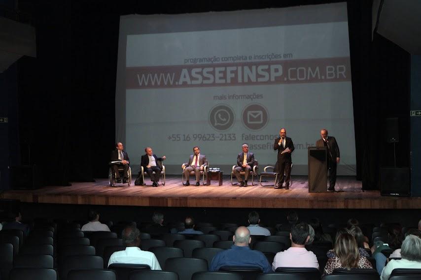 auditório com pessoas sentadas assistindo apresentação de pessoas no palco. #paratodosverem