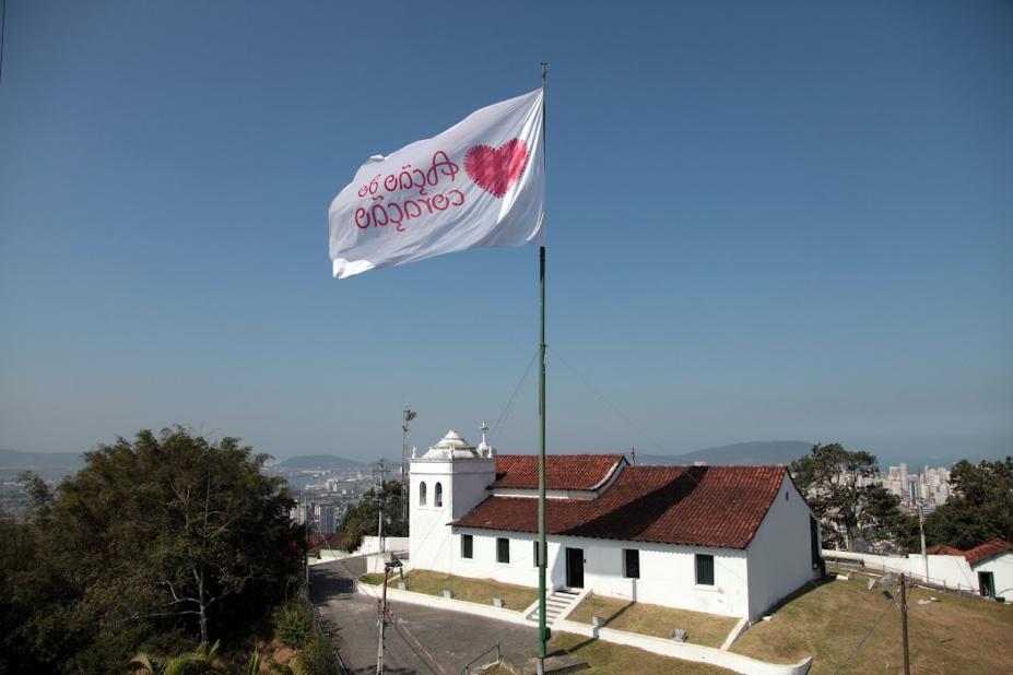 bandeira tremulando no alto do morro com igreja abaixo #paratodosverem