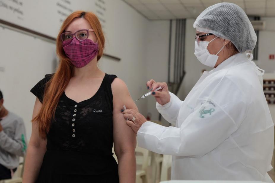 Mulher está recebendo aplicação da vacina de uma enfermeira - Fotos: Isabela Carrari