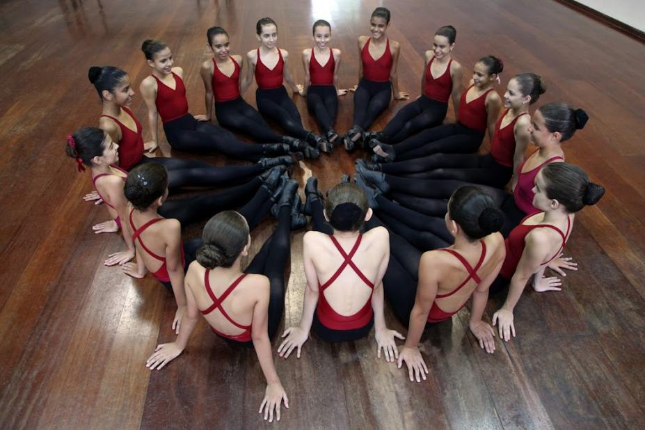 bailarinas sentadas em circulo no palco #paratodosverem