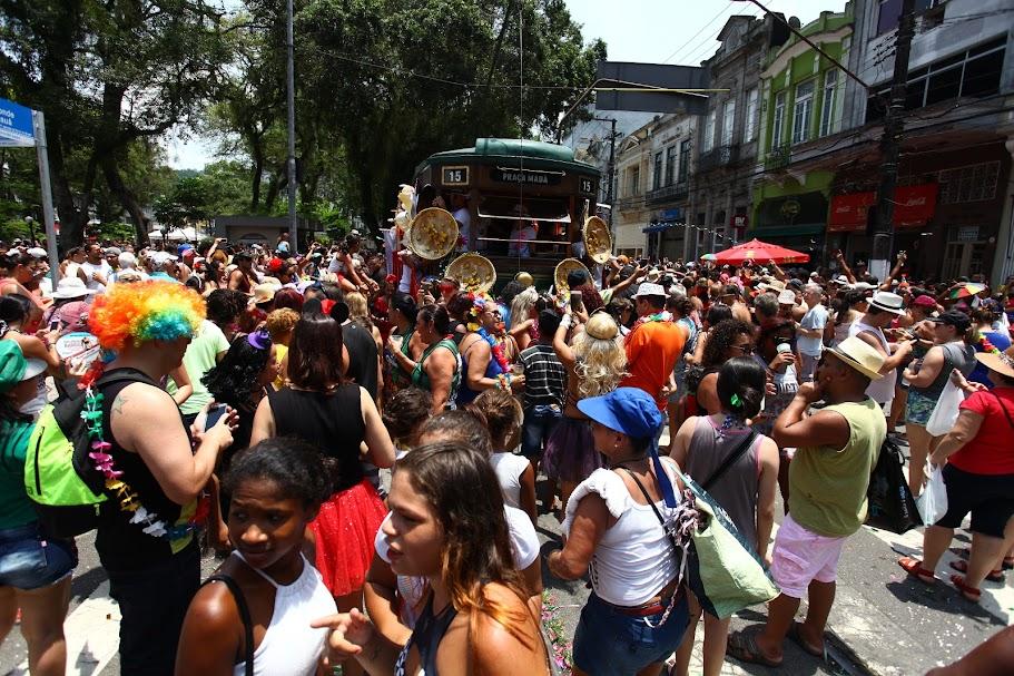 Festa do carnabonde, com praça lotada de gente e o bonde ao fundo. #paratodosverem 