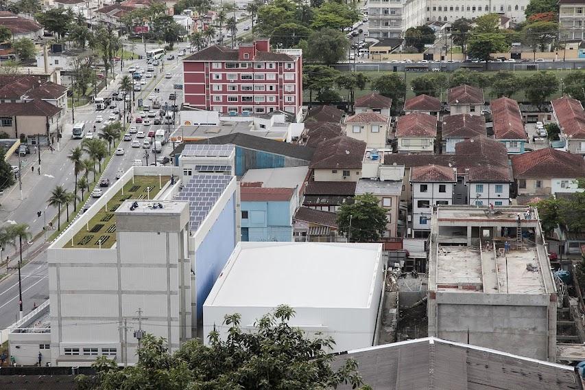 vista aérea de casas e edificações em geral com avenida ao lado esquerdo. #paratodosverem
