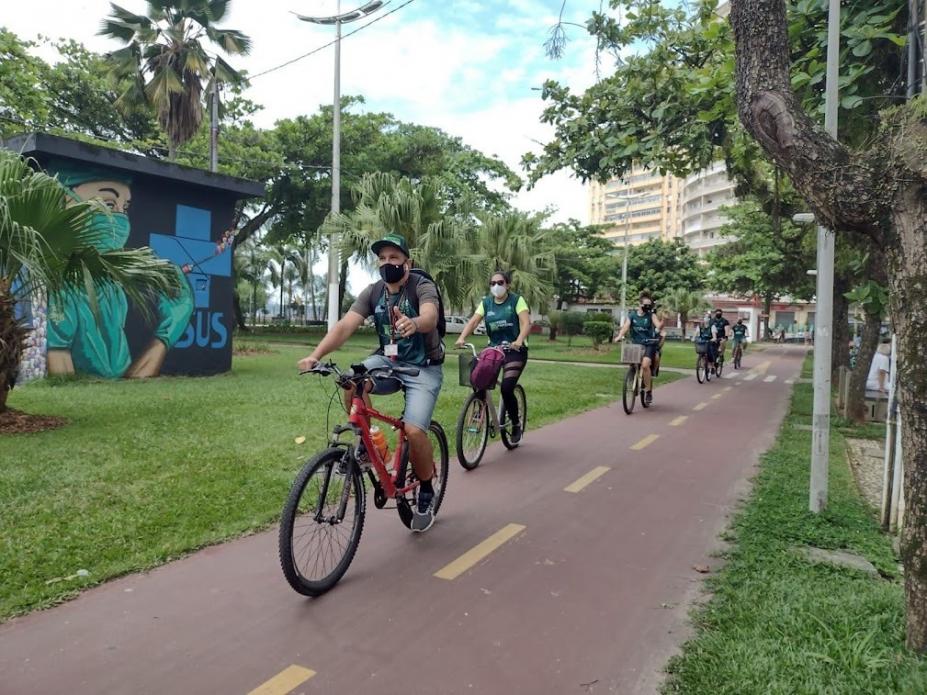 Pessoas andando de bicicleta na ciclovia da praia #paratodosverem