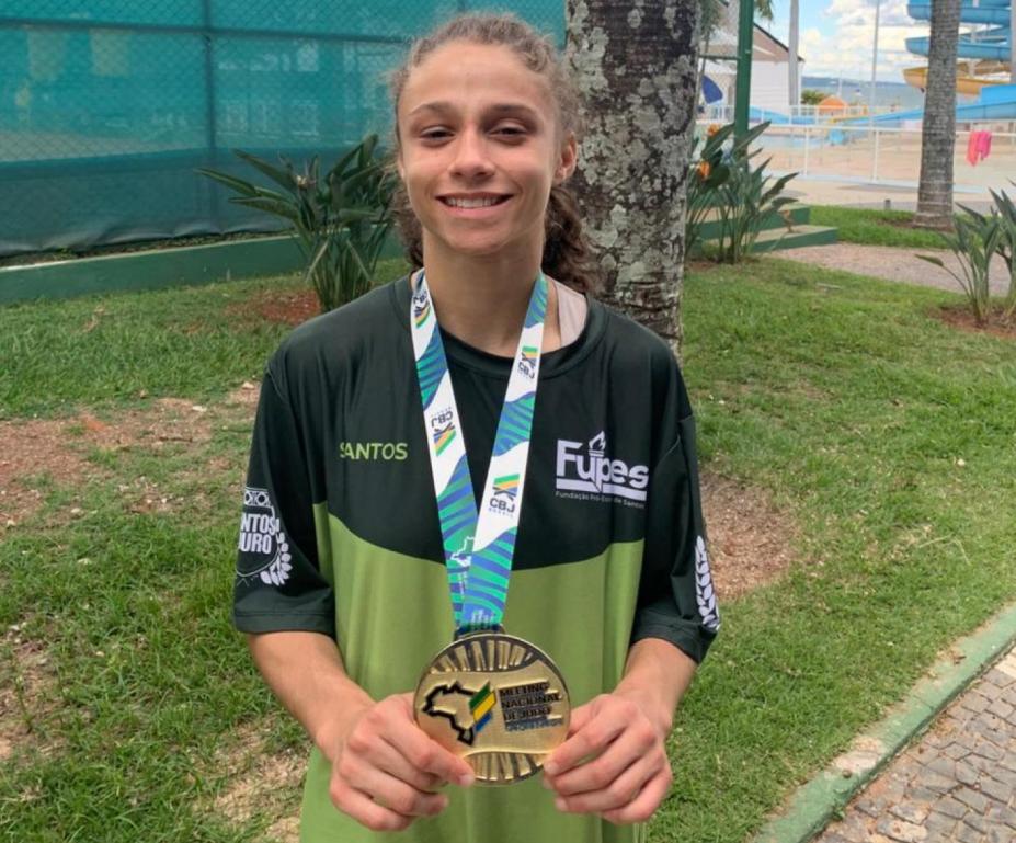atleta posa para foto segurando medalha de ouro #paratodosverem