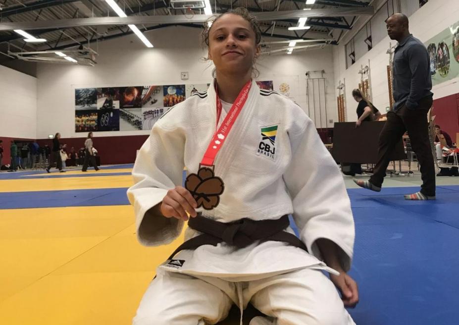 judoca de joelhos com a medalha ao peito #paratodosverem