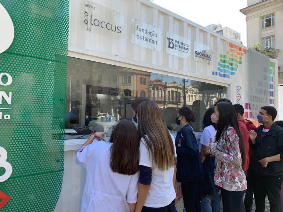 Estudantes observam laboratório dentro do container #paratodosverem