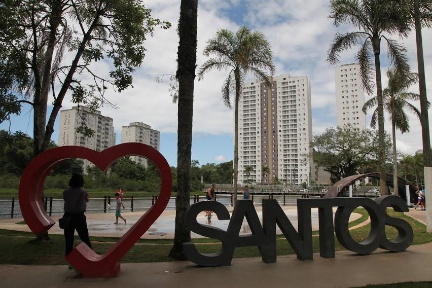 Escultura Eu Amo Santos, com o tradicional formato de coração, em frente à lagoa. #pracegover