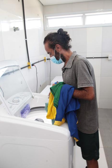 Homem retira roupas de máquina de lavar. #pratodosverem