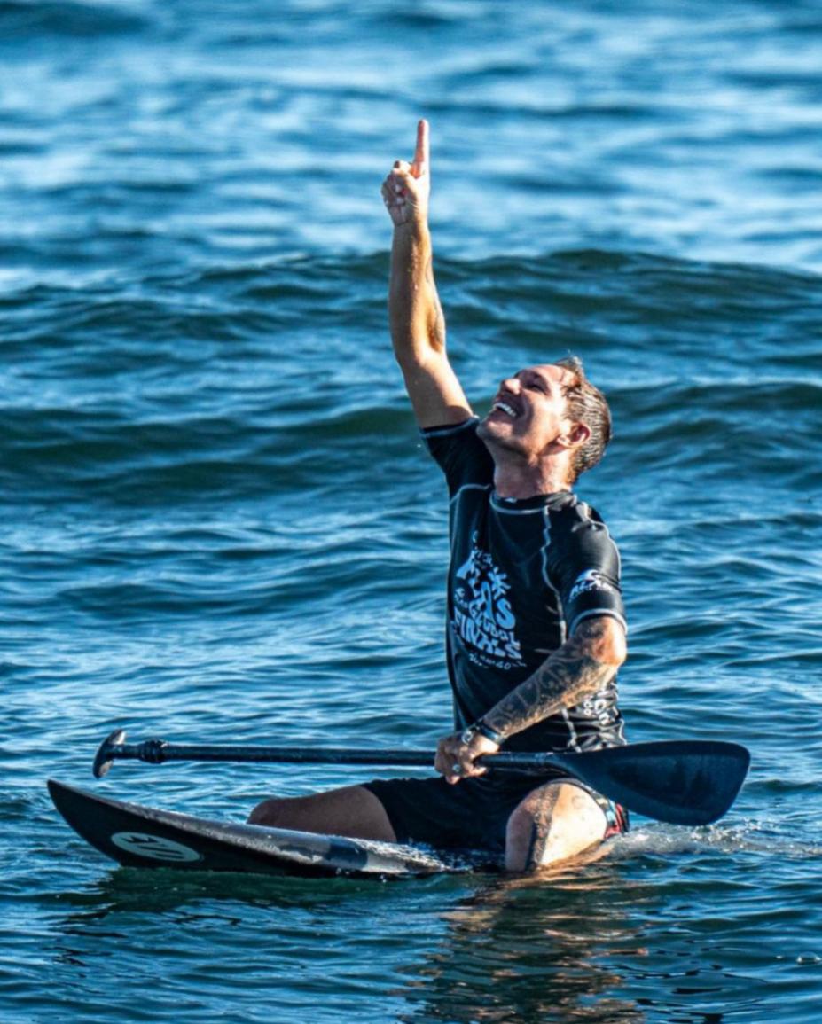 Surfista comemora vitória no mar. #Paratodosverem.