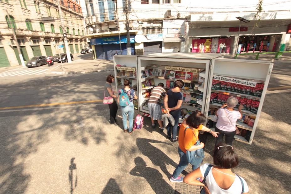pessoas pegando livros no estande #paratodosverem 