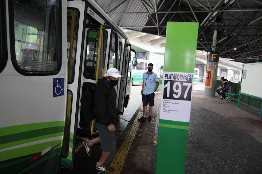 homem sai de ônibus parado diante de toten com identificação do número da linha 197. #paratodosverem