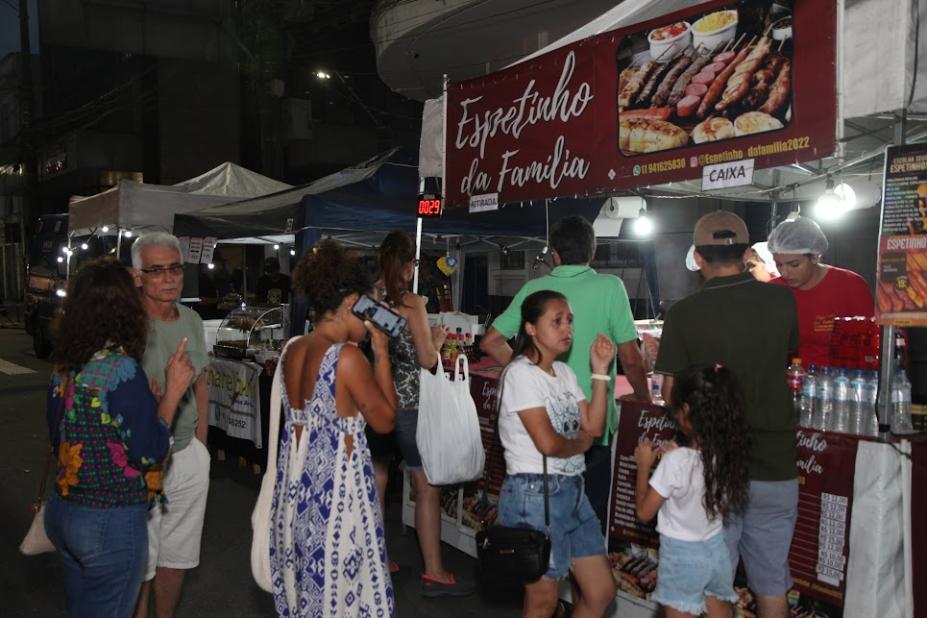 barraca de espetinho com pessoas em torno. #paratodosverem 