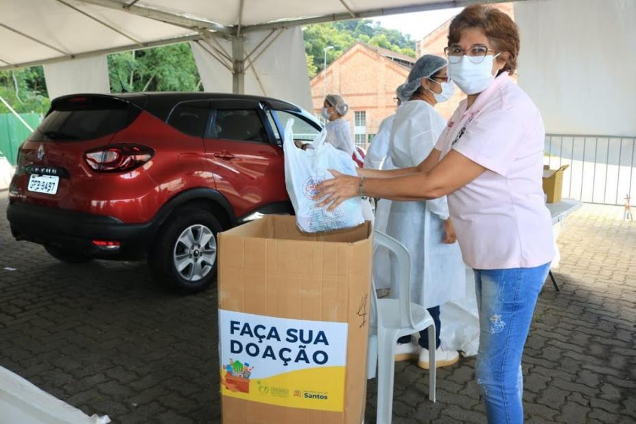 mulher coloca doação em caixa #paratodosverem 