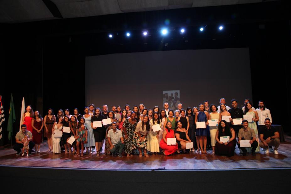 formandos estão em palco posando para foto. #paratodosverem 