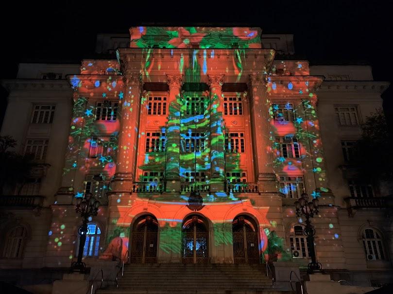 fachada da prefeitura com projeção de pinheiro de natal à noite. #paratodosverem 