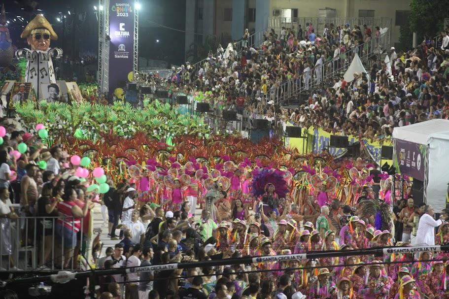 passarela com escola de samba passando e grande público em torno. #paratodosverem 