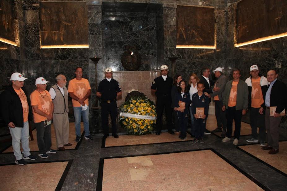 comitiva e autoridades posam com coroa de flores #paratodosverem