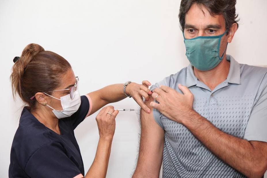 mulher vacina homem no braço. #paratodosverem