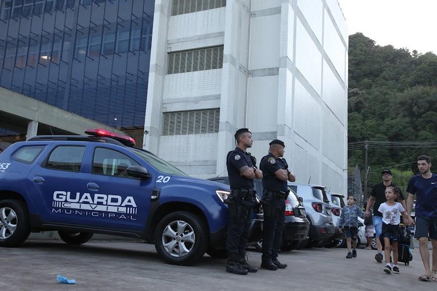guardas municipais estão na porta de escola com alunos chegando. #paratodosverem