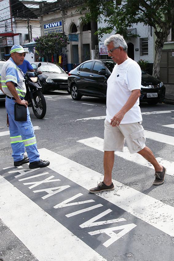 Agente da CET observa pedestre atravessar na faixa #pracegover