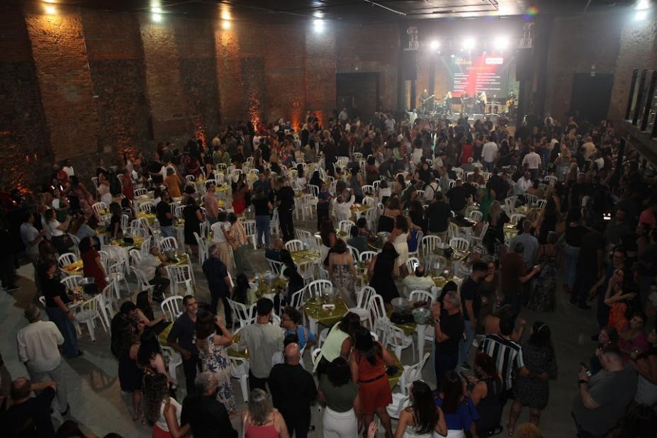 festa com centenas de pessoas em pé e sentadas. #paratodosverem