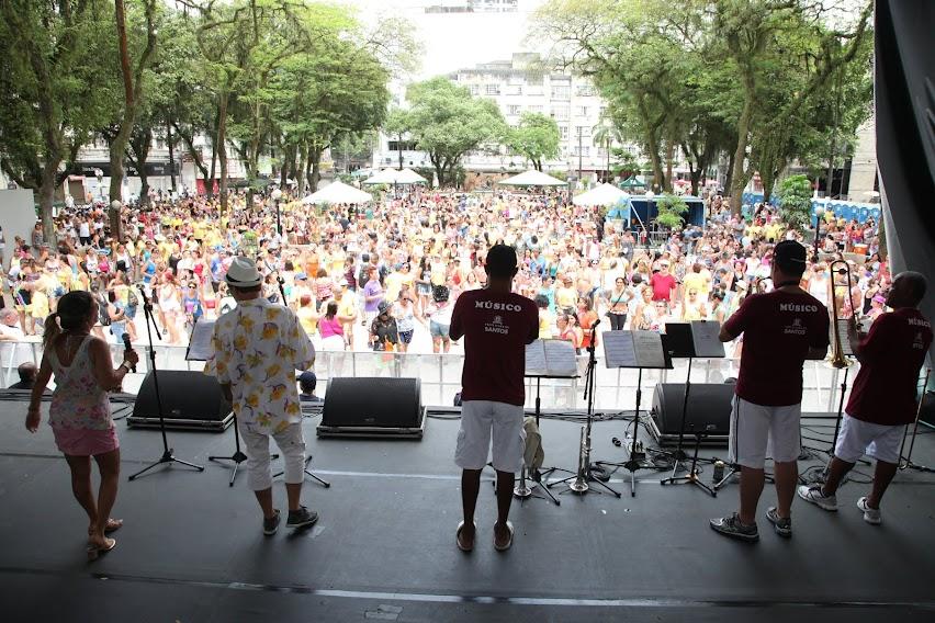 músicos de costa para a foto em palco na praça mauá, com grande público ao fundo. #paratodosverem