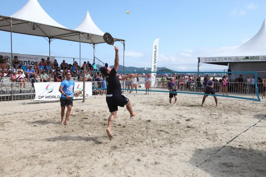 duas duplas jogando beach tennis. A rede está entre elas. #paratodosverem 