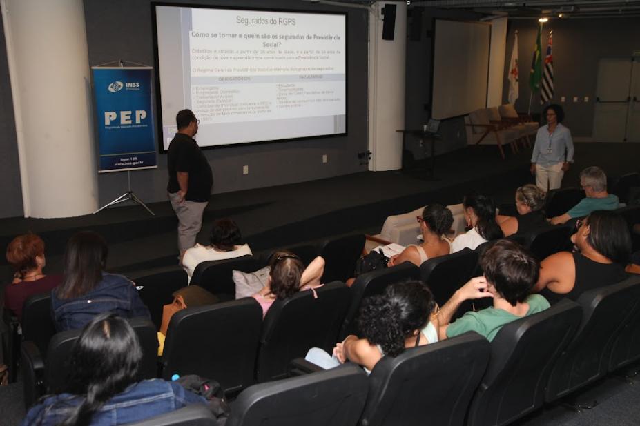 palestra em auditório com pessoas sentadas em um telão à frente. #paratodosverm